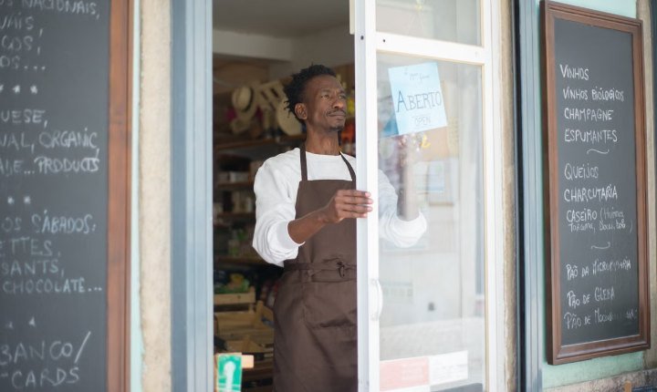 Shop owner in an apron opening up for the day