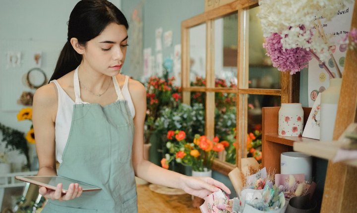 Florist checking her orders on a tablet in her shop